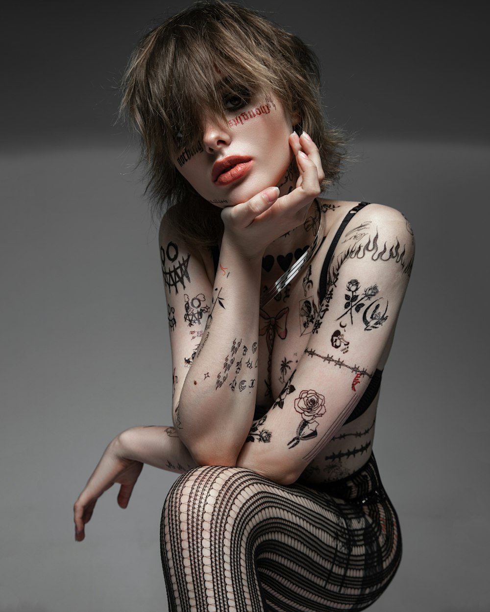 a woman with tattoos on her body posing for a picture