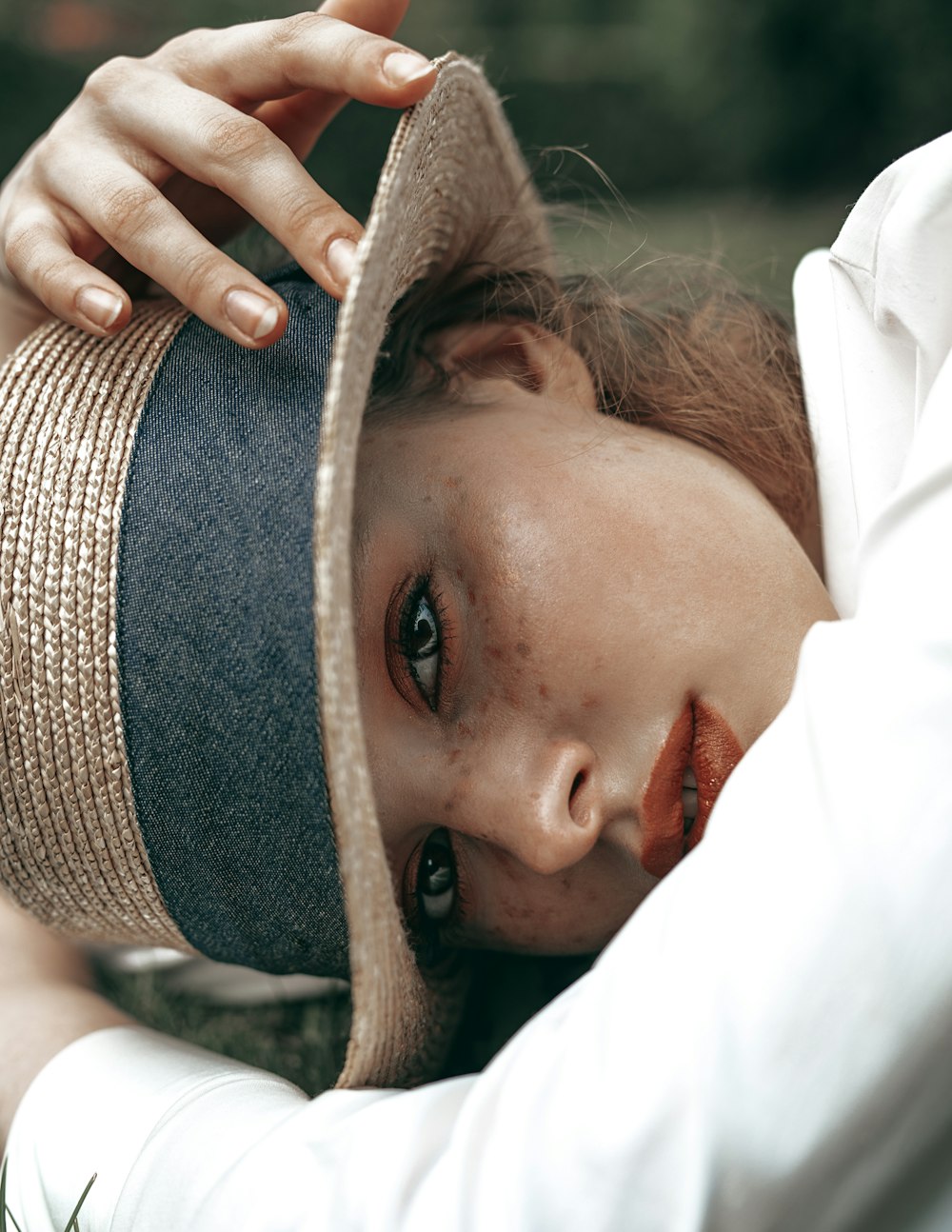 a woman with freckled hair wearing a hat