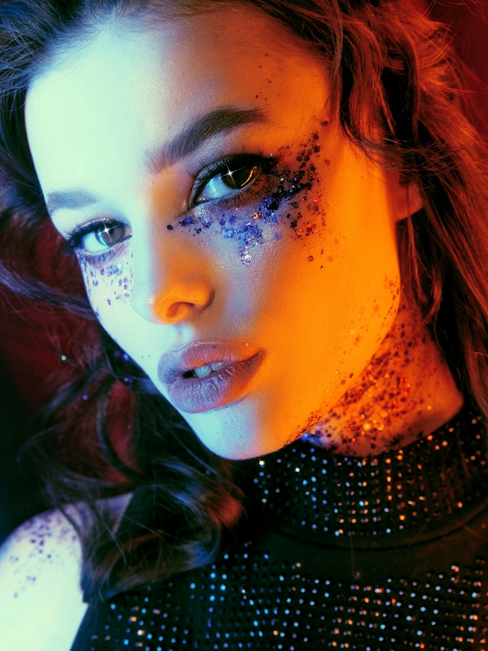a woman with glitter on her face posing for a picture