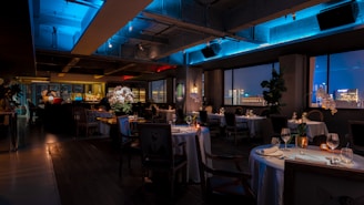 a dimly lit restaurant with a view of the city