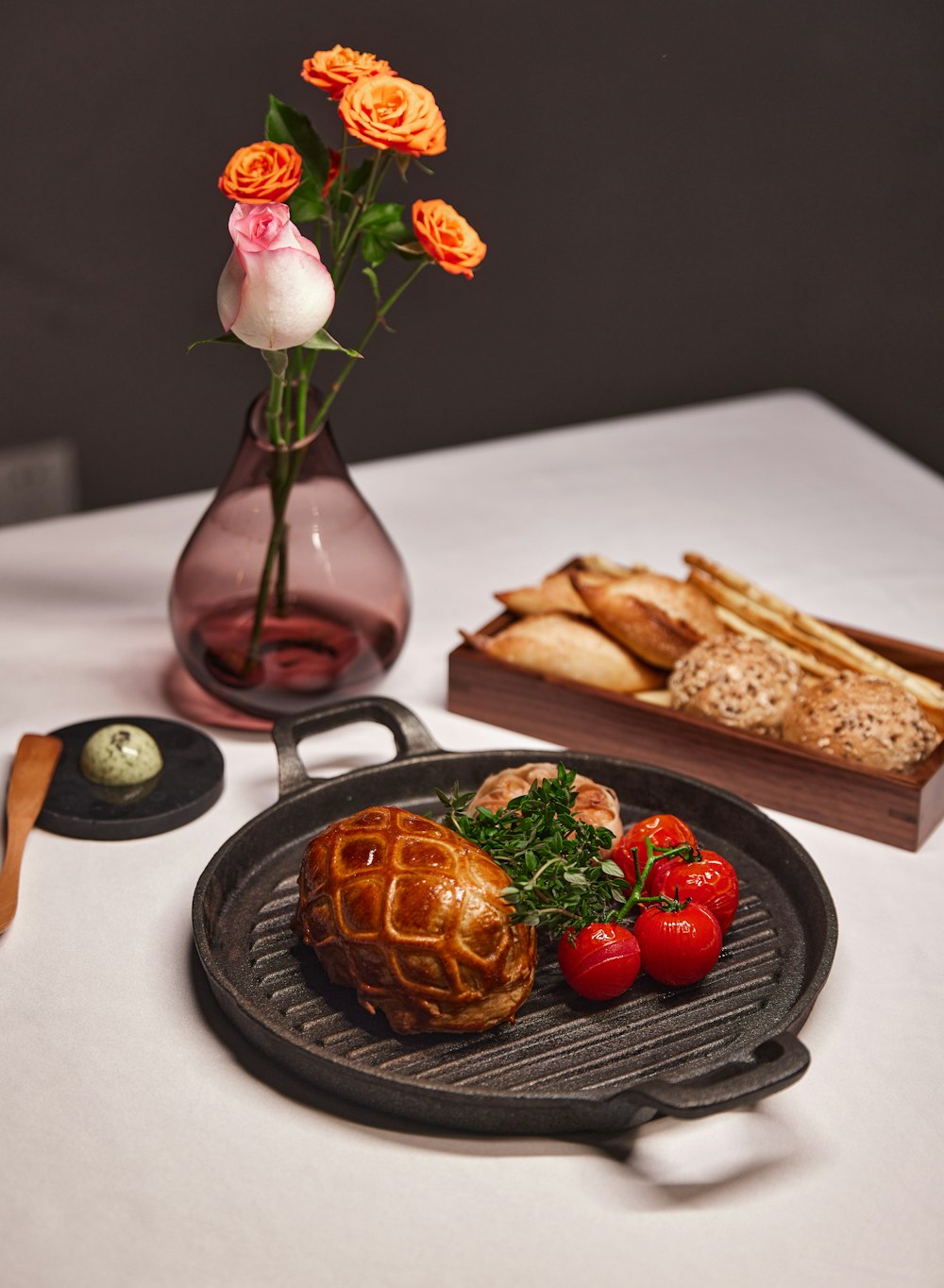 a plate of food on a table with a vase of flowers