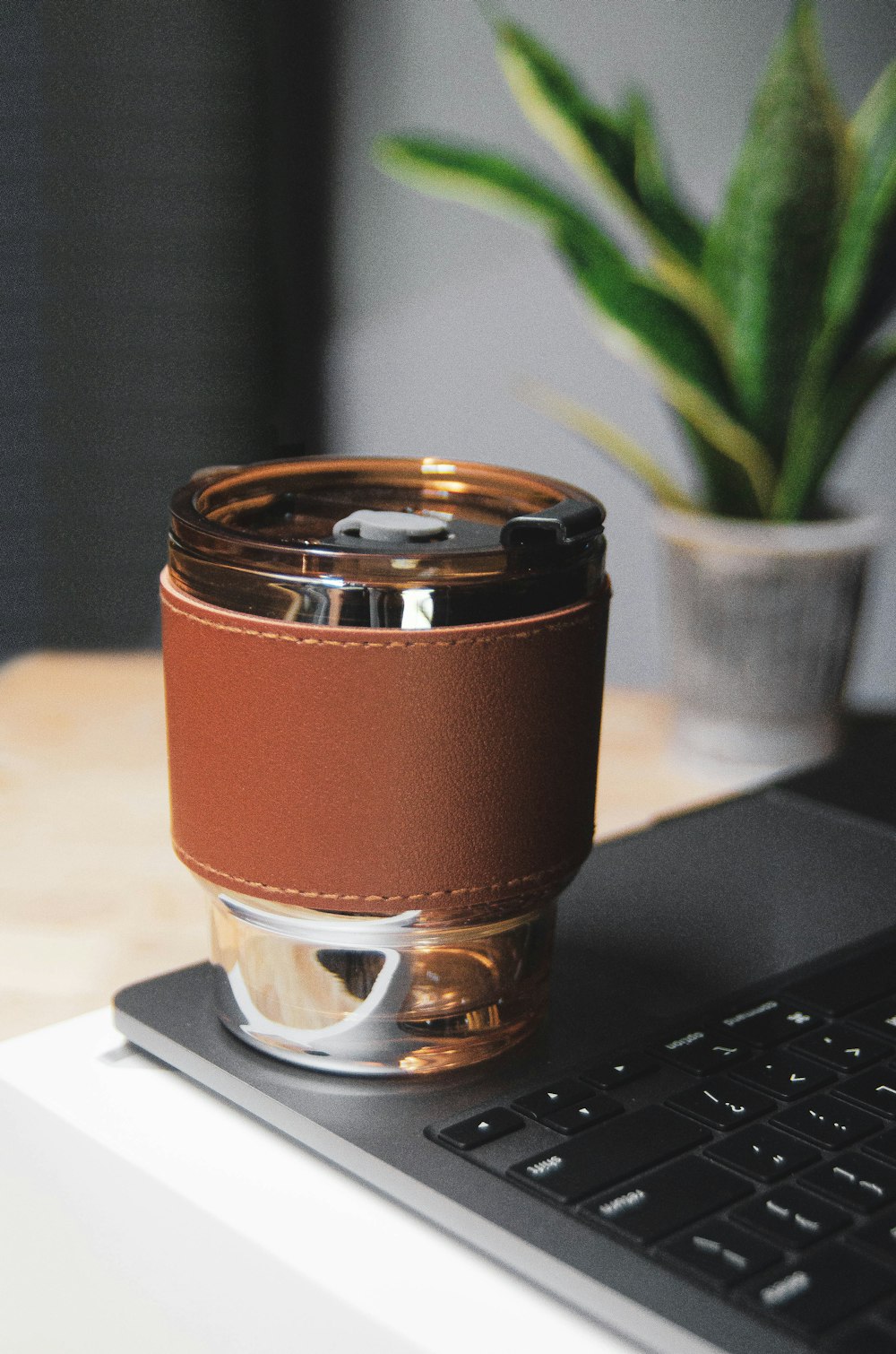 una tazza di caffè seduta sopra un computer portatile