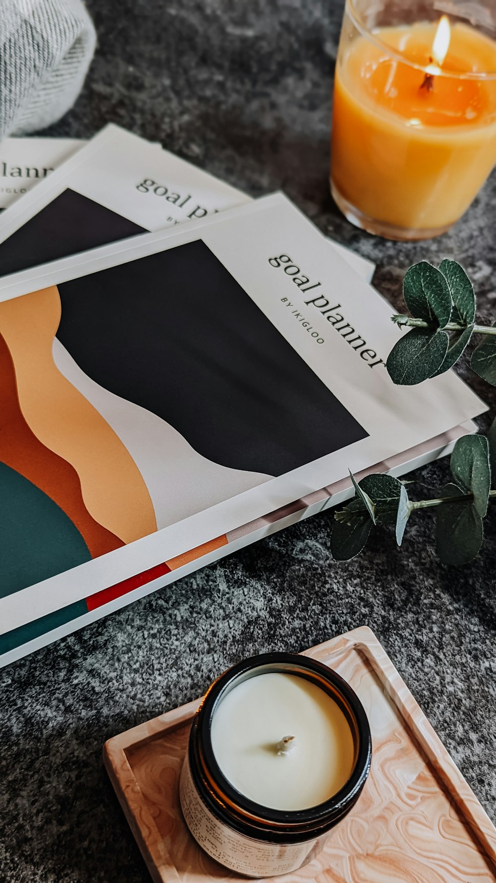 a candle sitting on top of a table next to a book