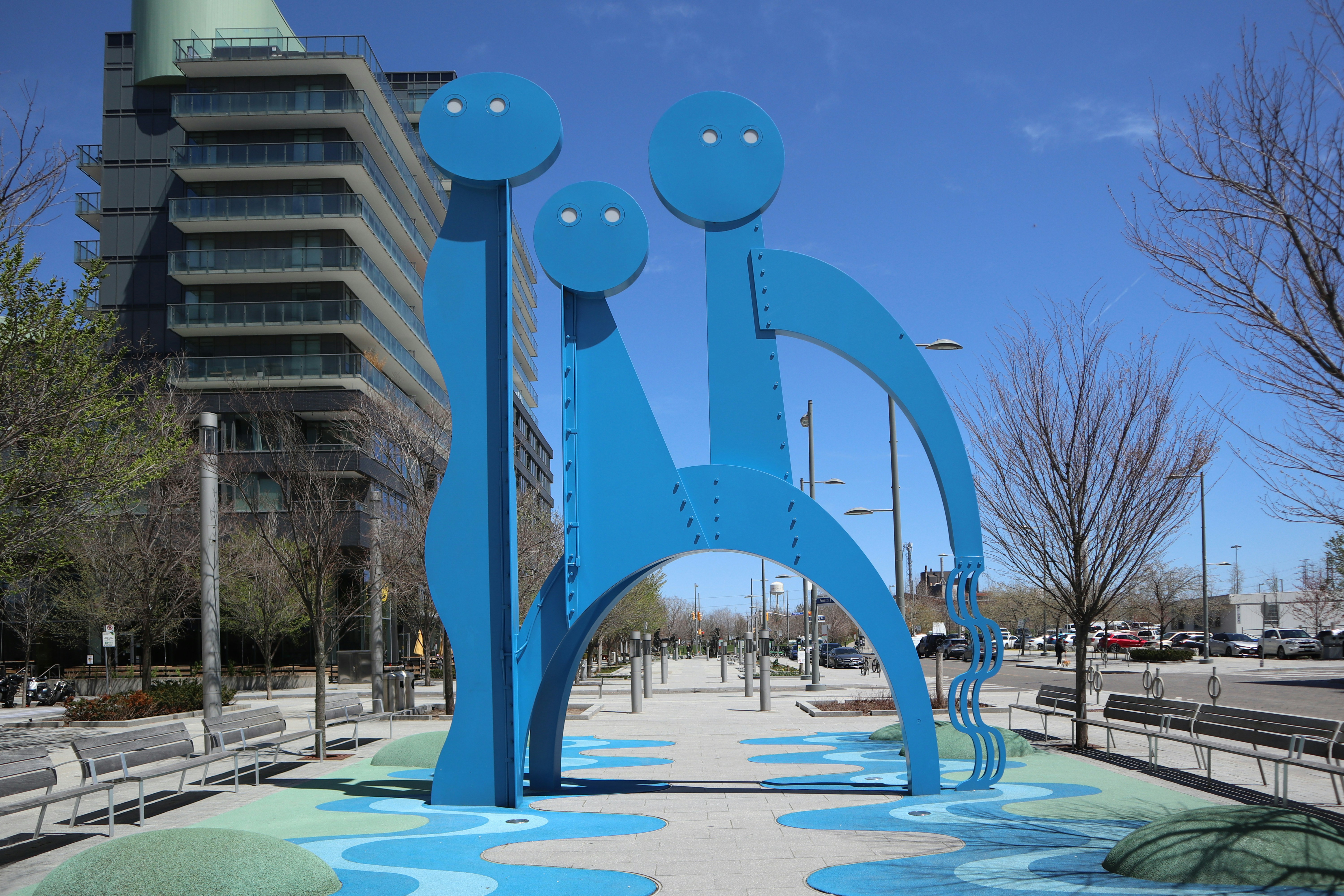 a blue sculpture in the middle of a park