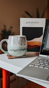 a laptop computer sitting on top of a white desk
