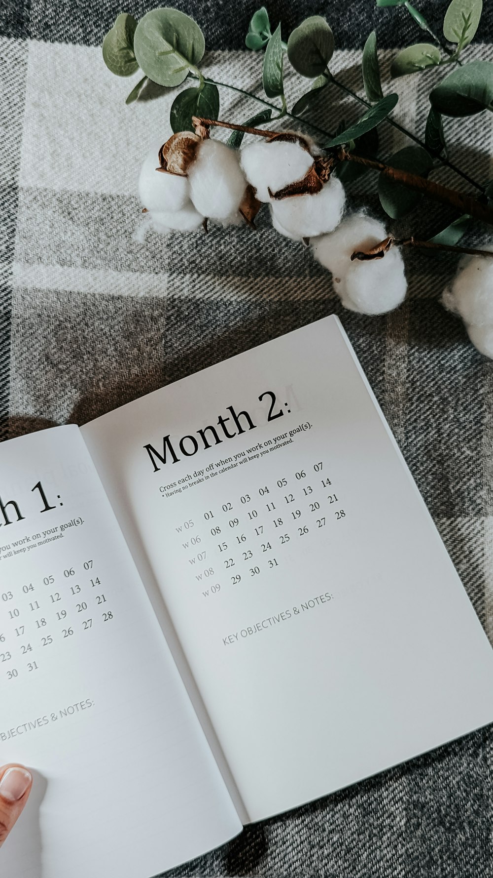 a person holding a book open to a calendar