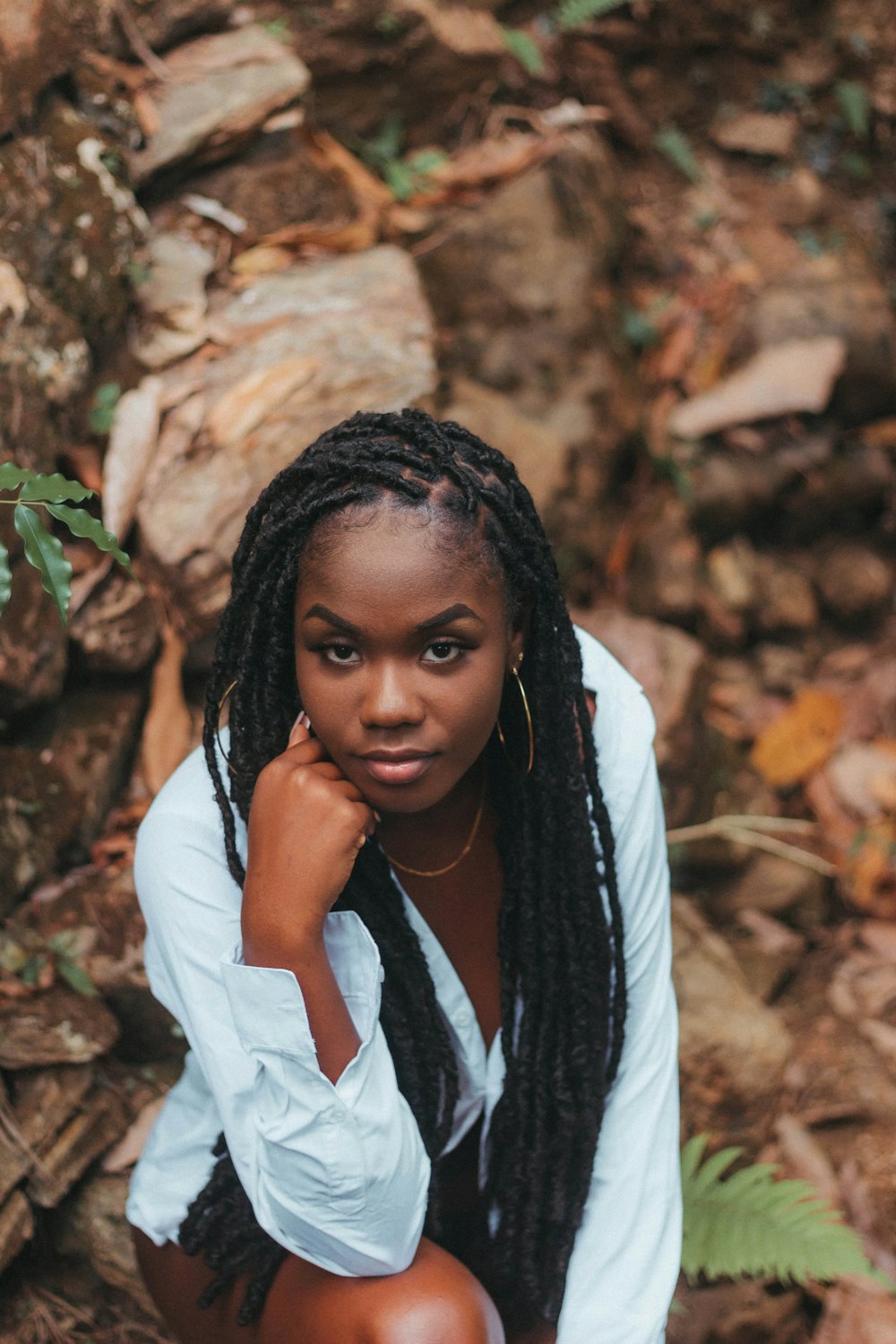 a woman with dreadlocks sitting on the ground