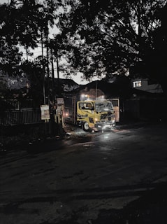 A bright yellow tow truck from Grúas V&G assisting a stranded car at dusk on a Nicaraguan highway