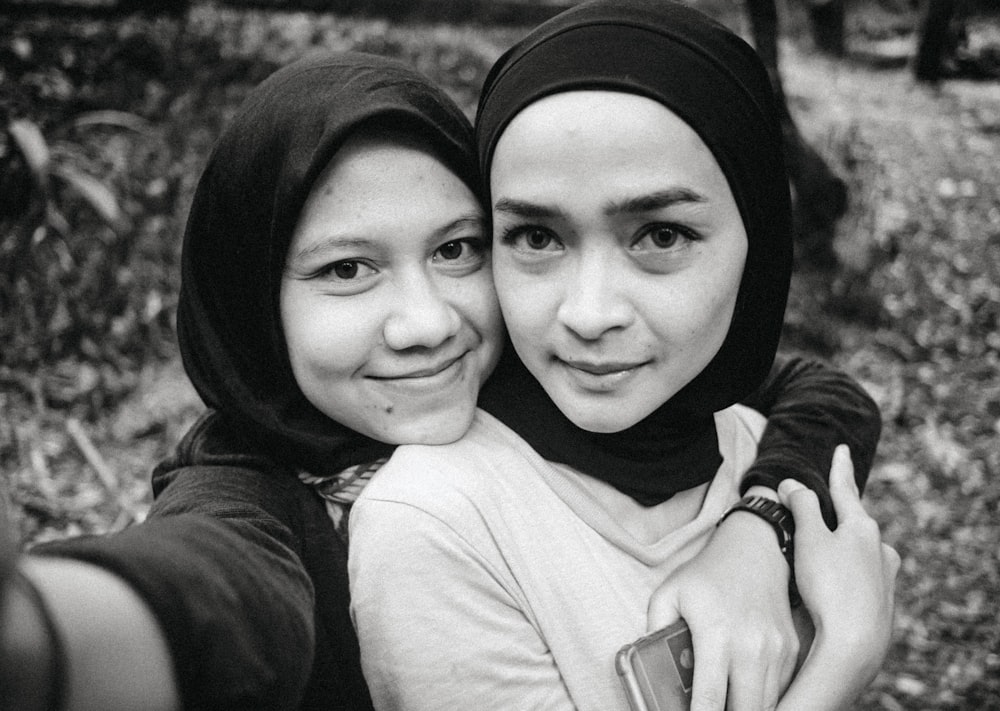 two women are taking a selfie in a black and white photo