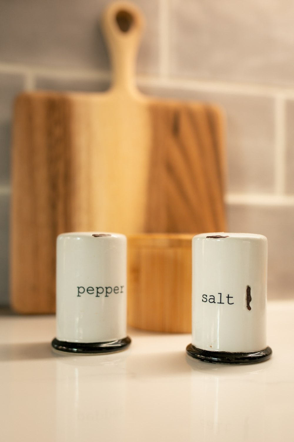 two salt and pepper shakers sitting on a counter
