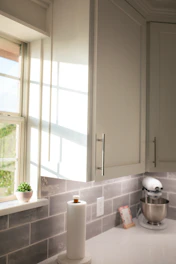 a kitchen with a white counter top next to a window