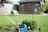 a yard with a lawn mower, garden tools and a birdhouse