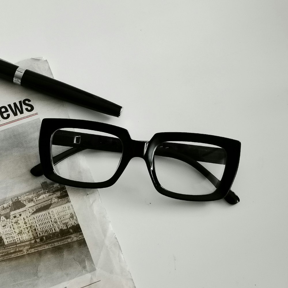 a pair of glasses sitting on top of a newspaper