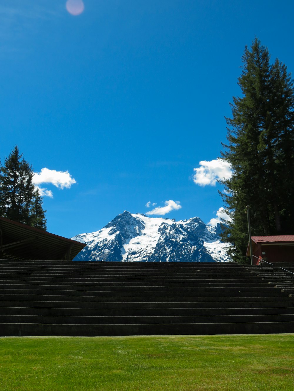 a grassy field with steps leading up to a mountain