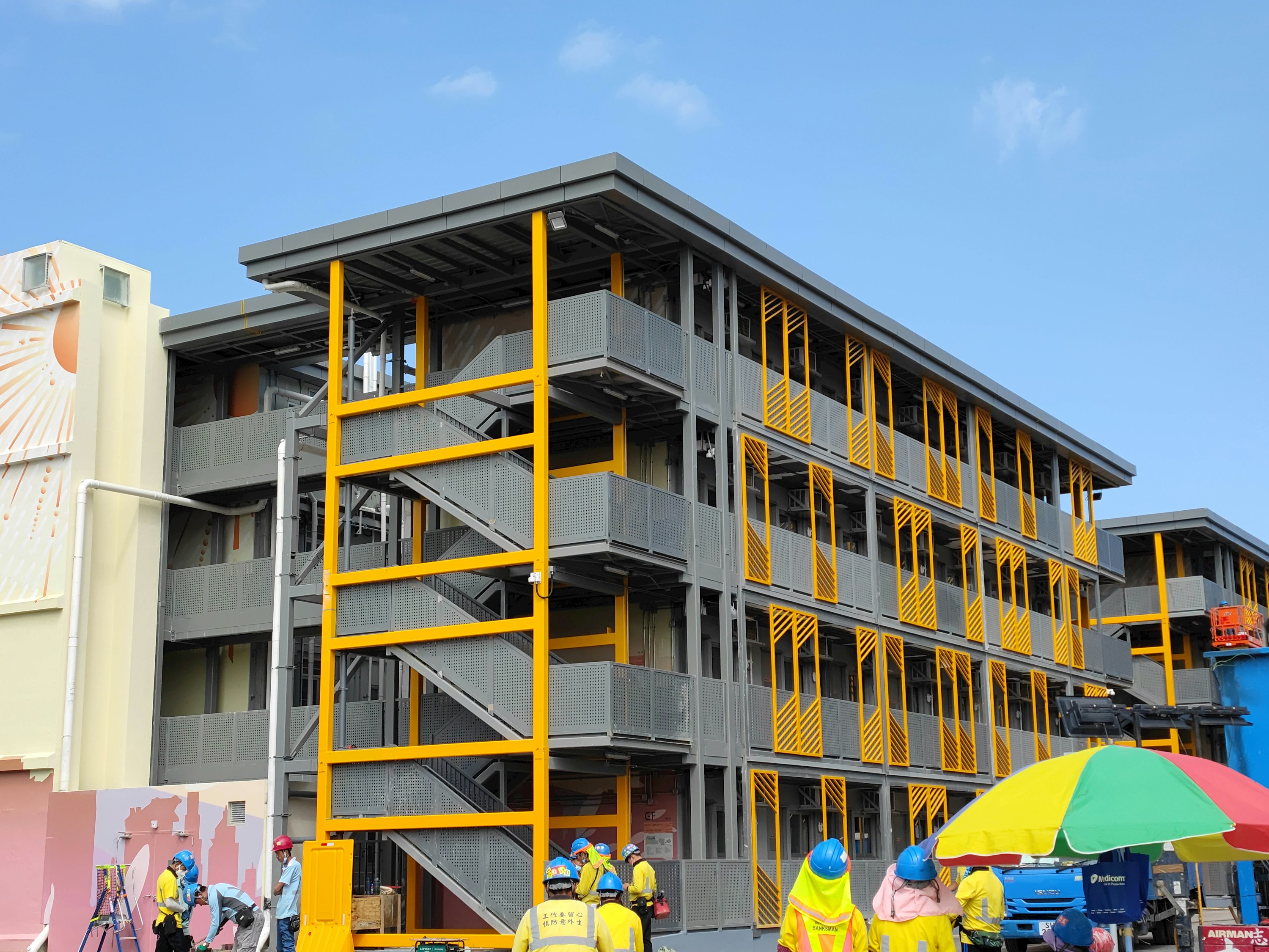Group of people in front of a building under construction modular