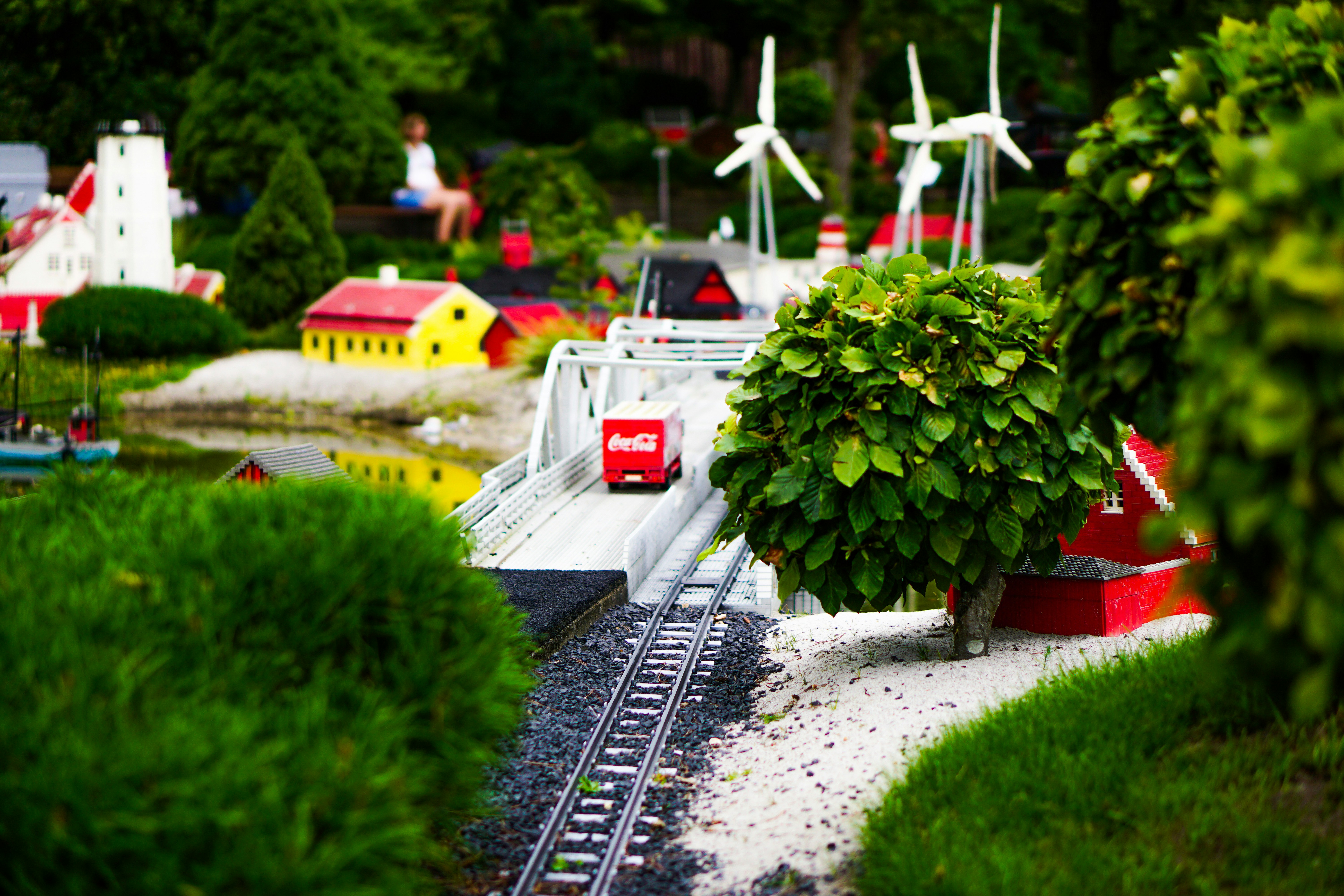 a model of a train track with a tree and windmills in the background, 