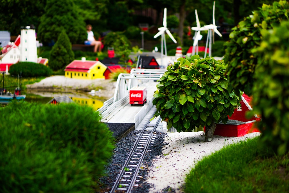 une maquette d’une voie ferrée avec un arbre et des moulins à vent en arrière-plan