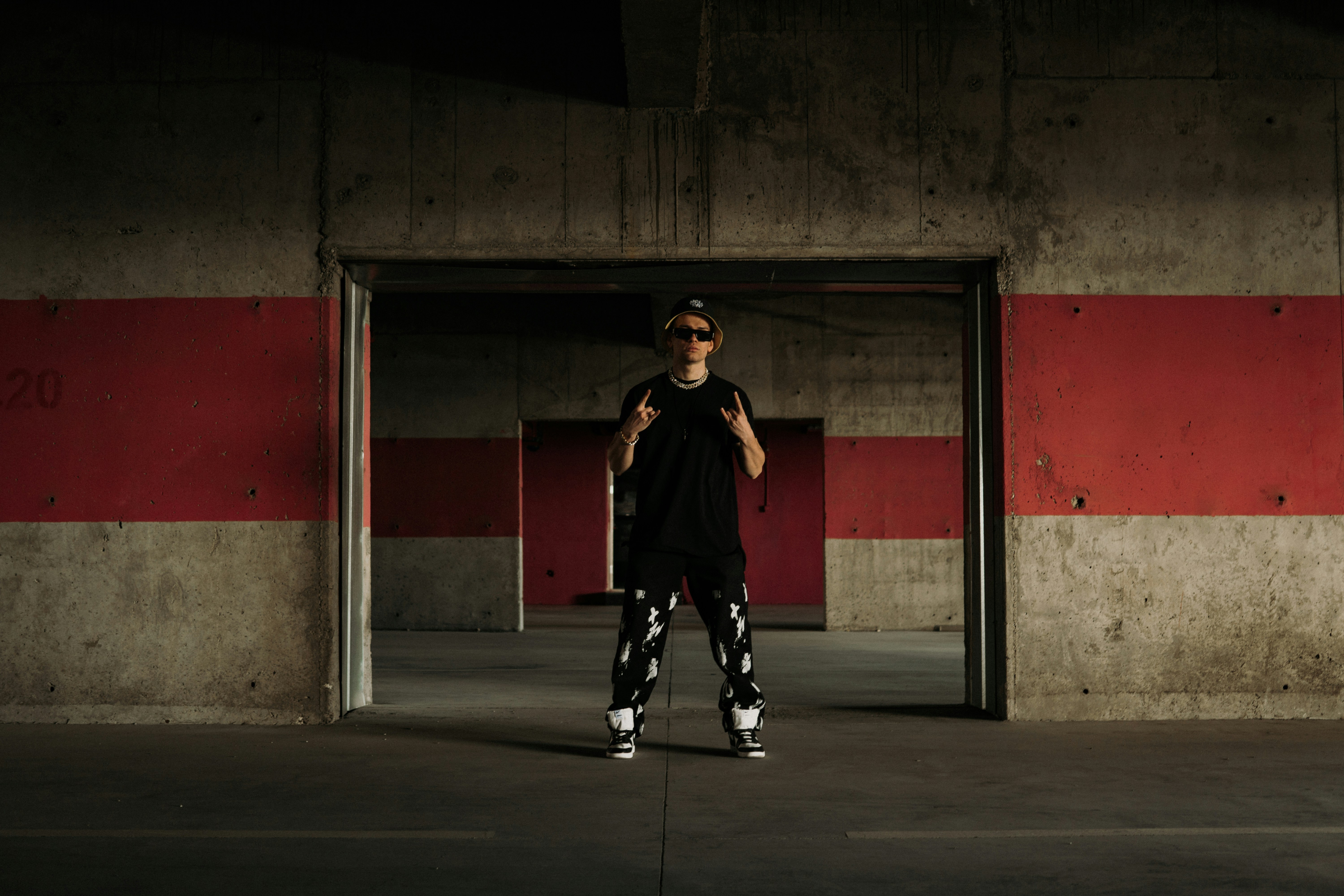 a man standing in a parking garage holding a skateboard