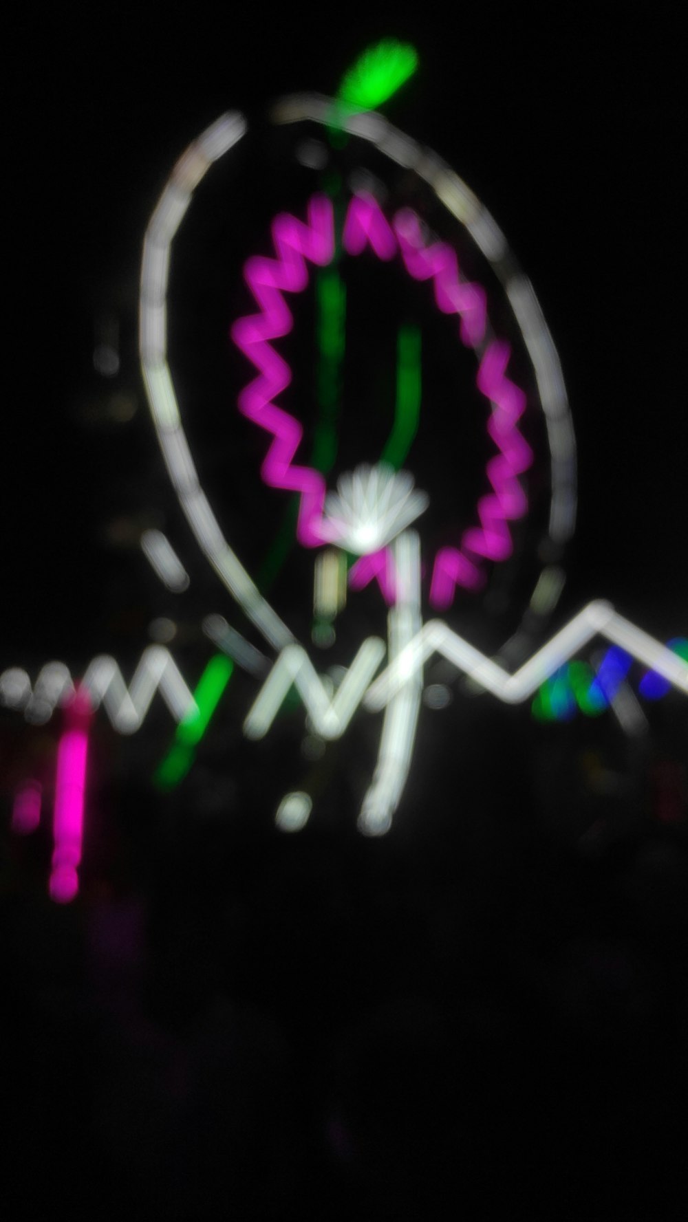 a blurry photo of a ferris wheel at night