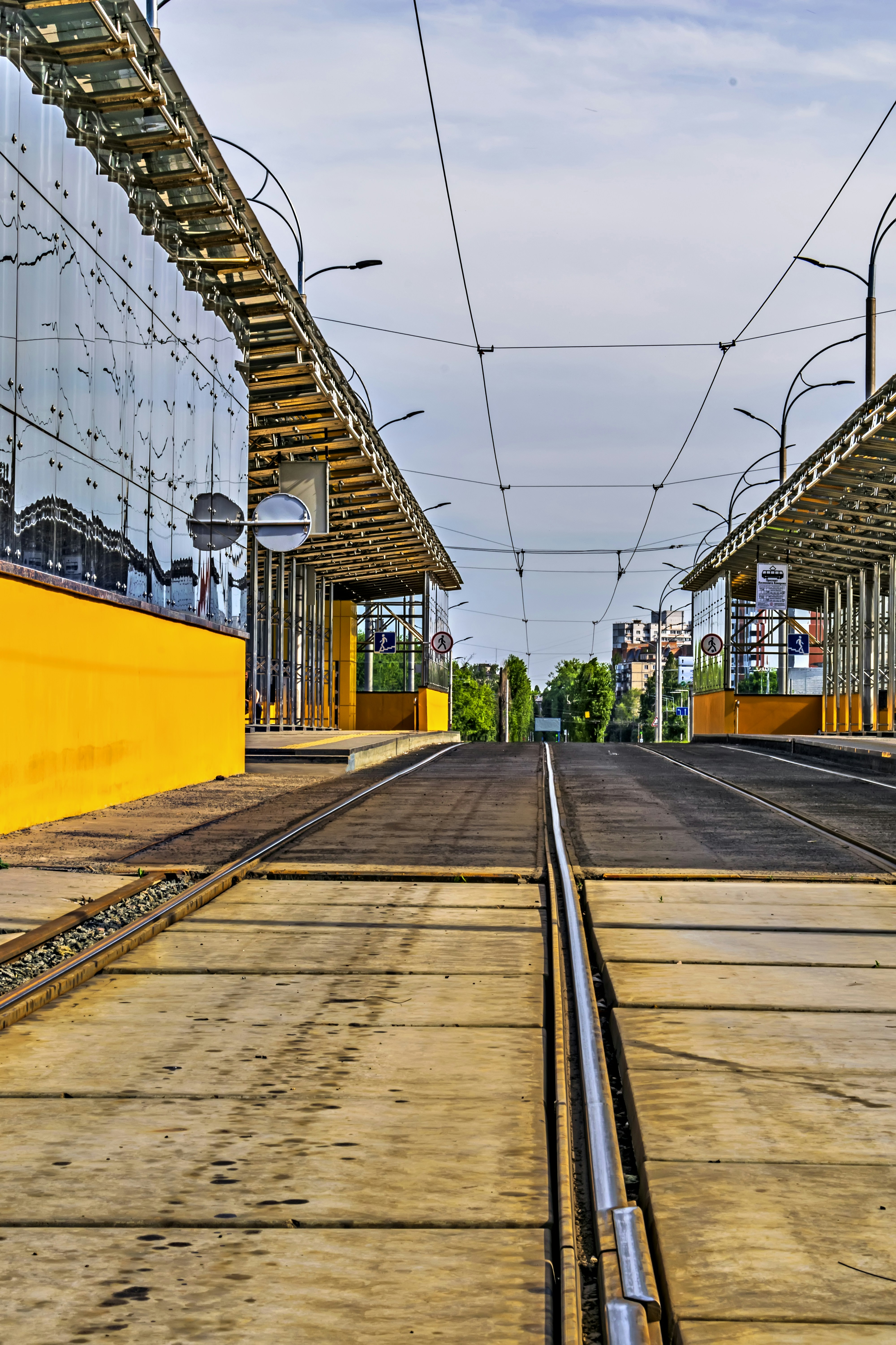 a train track with a yellow building in the background