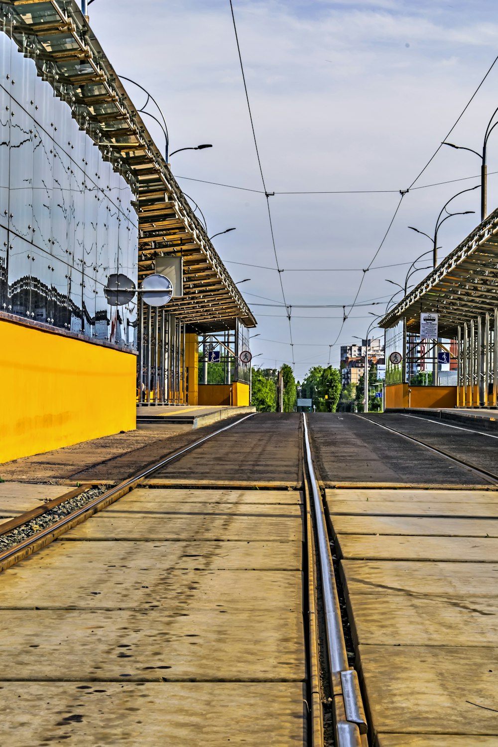 a train track with a yellow building in the background