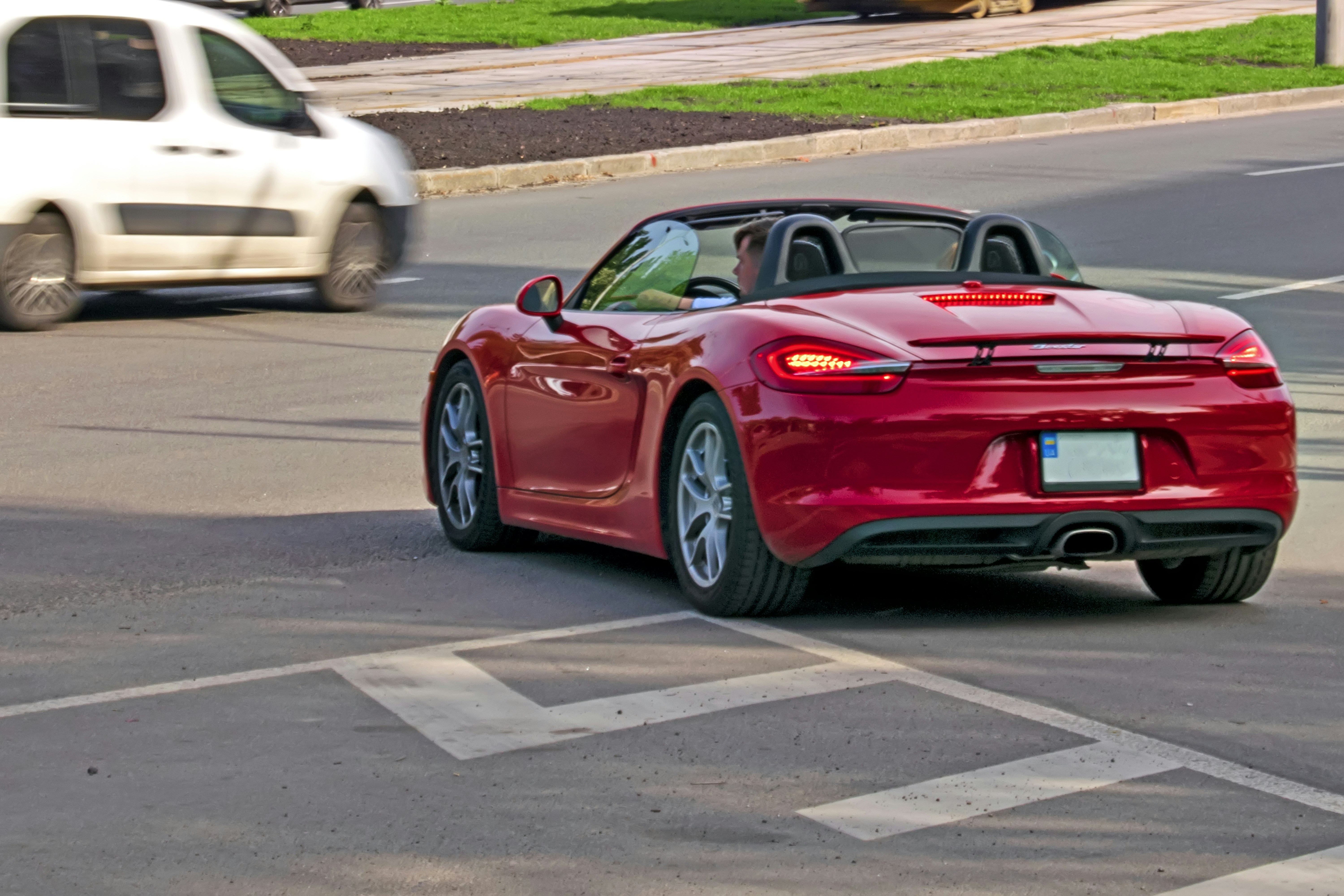 Un'auto sportiva rossa che guida lungo una strada