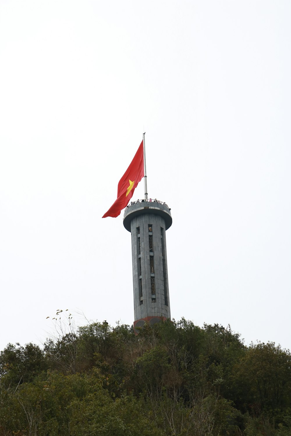 a flag flying on top of a tall tower