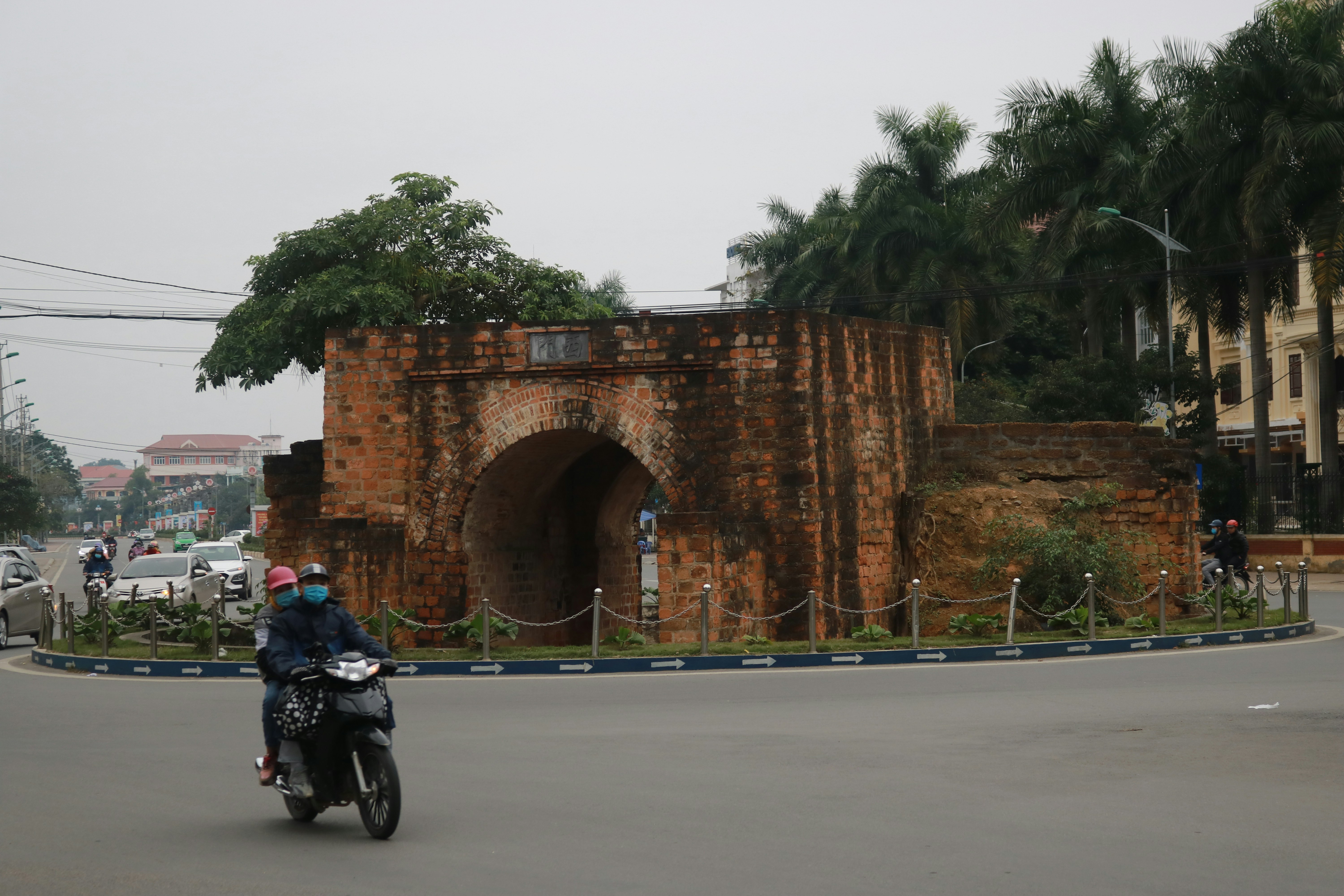 Seorang pria mengendarai sepeda motor di jalan