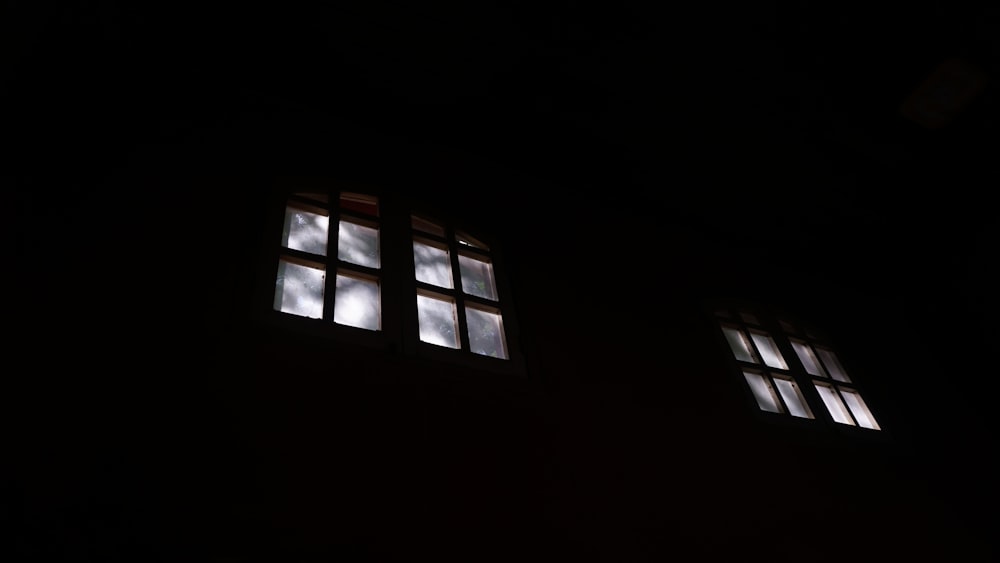 three windows in a dark room with light coming through them
