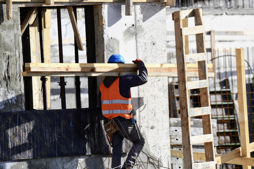 Un operaio edile sta lavorando sul lato di un edificio