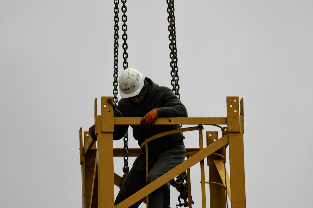 a man in a white helmet is on a crane
