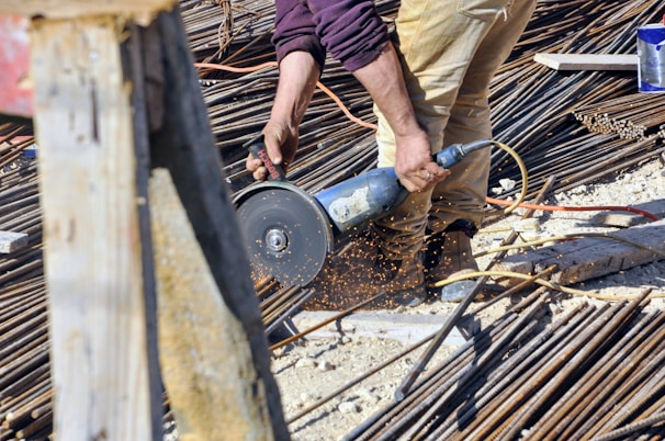 Workers cutting custom-sized mesh panels precisely for a construction project.