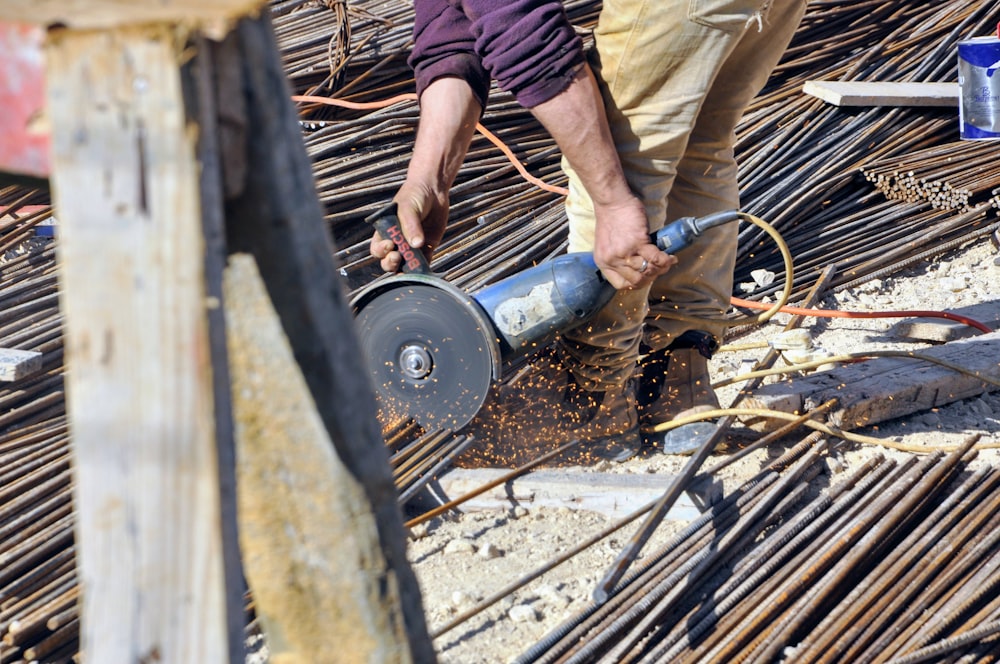 a man using a circular saw to cut a piece of wood