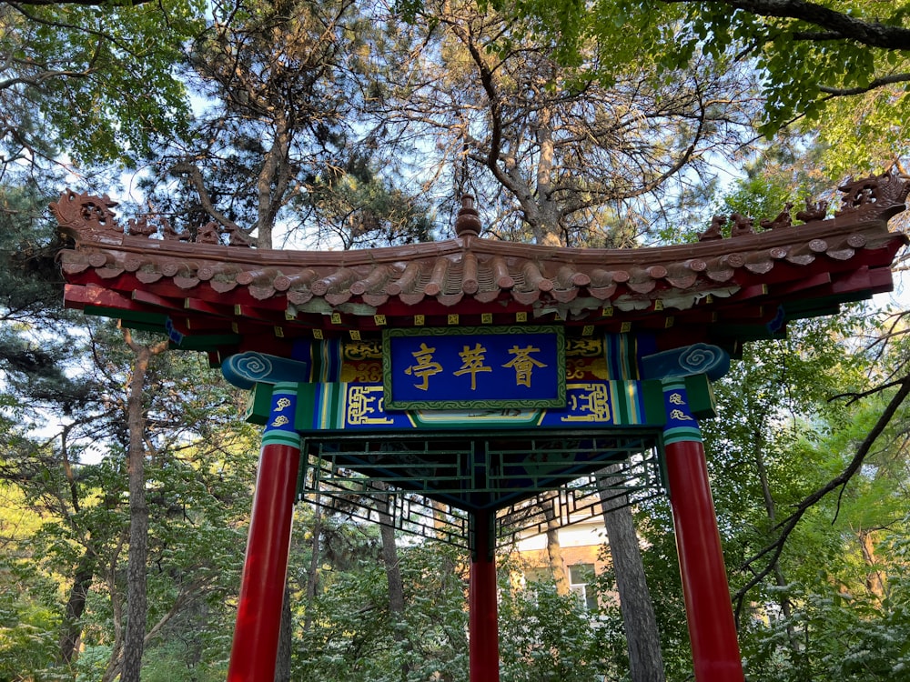a red and blue pagoda in the middle of a forest