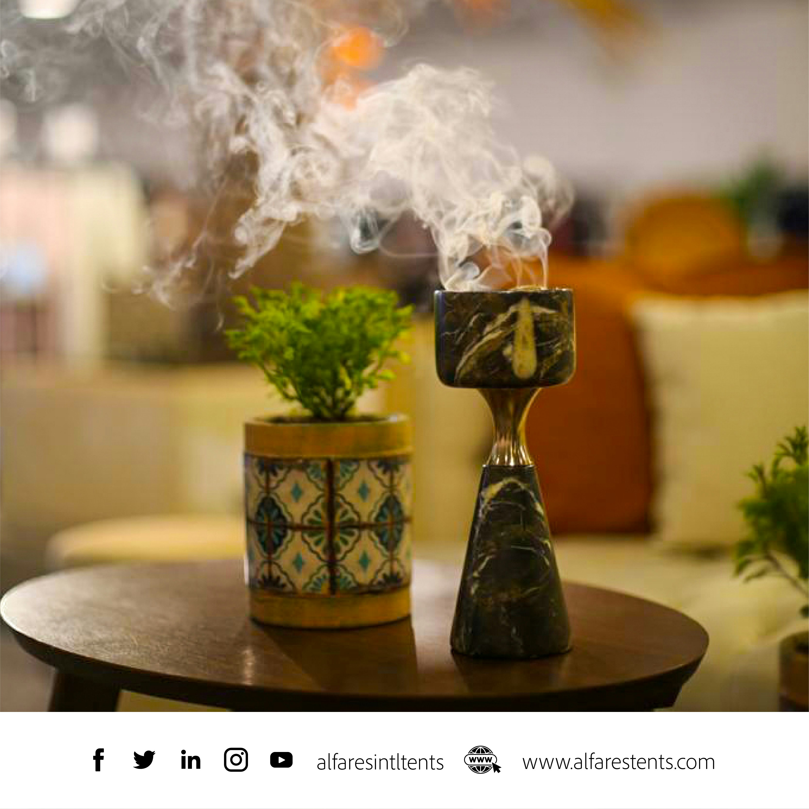 a wooden table topped with a potted plant next to a candle holder