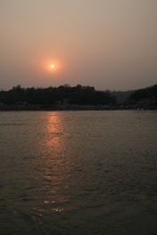 the sun is setting over a body of water