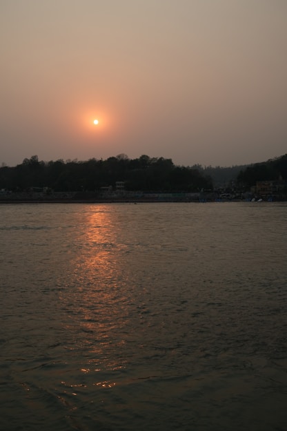 the sun is setting over a body of water