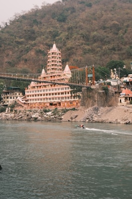a large building sitting on top of a hill next to a body of water