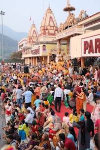 a crowd of people sitting on the ground in front of a building