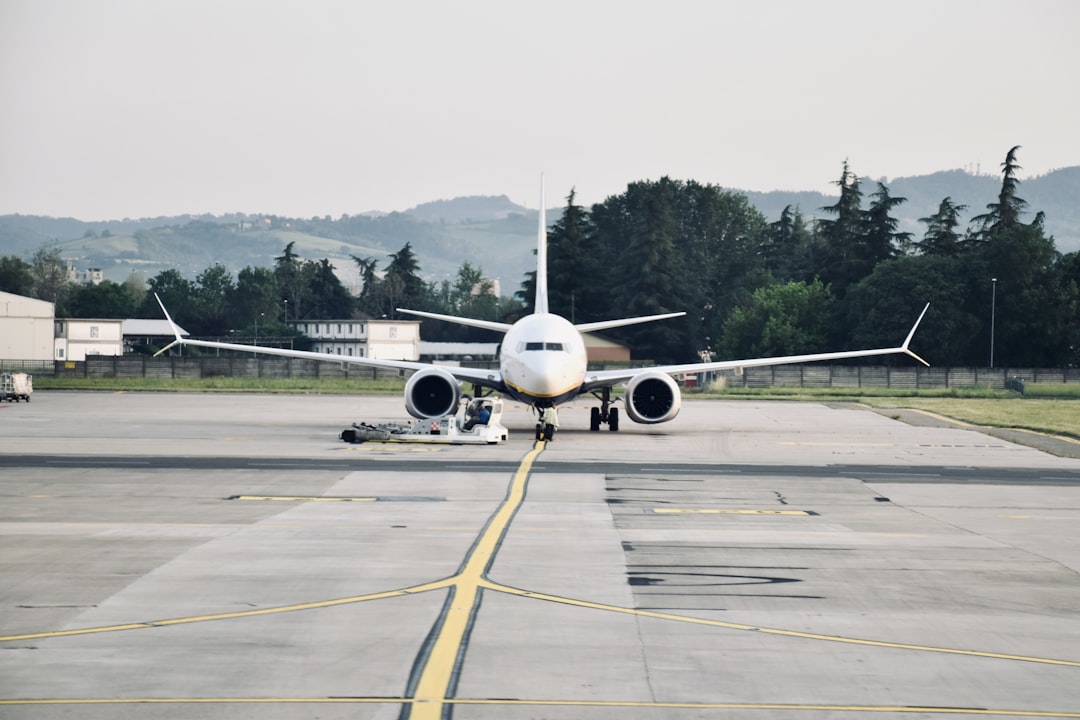a large passenger jet sitting on top of an airport tarmac, A Boenig 737-Max of Ryanair getting ready for being towed.