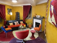 A vibrant living room with colorful carpets and wall art.