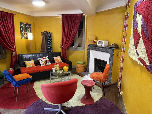 A warm, inviting living room featuring vibrant yellow and black furniture pieces from šiluma namai.