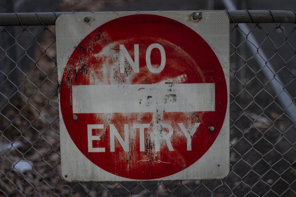 a no entry sign on a chain link fence
