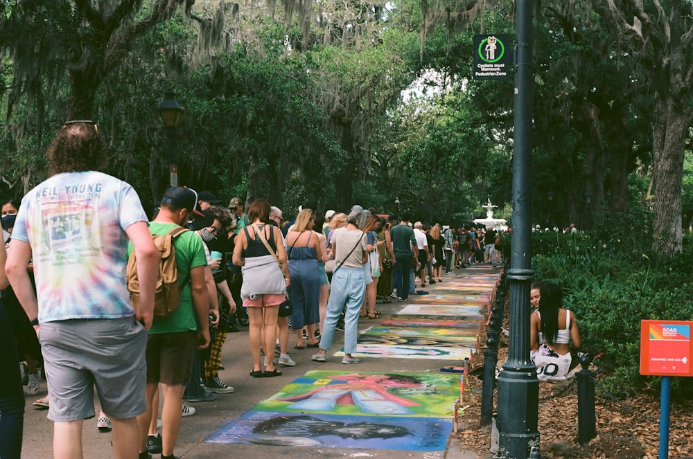 a group of people walking down a sidewalk