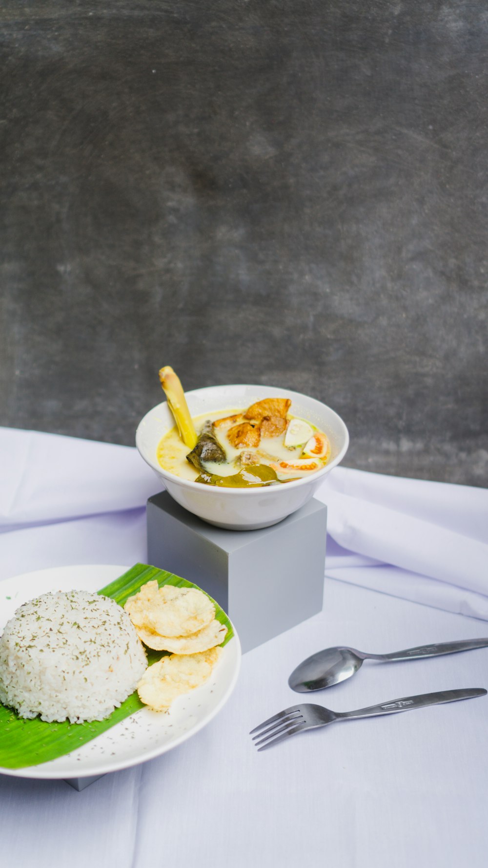 a bowl of soup and a plate of food on a table