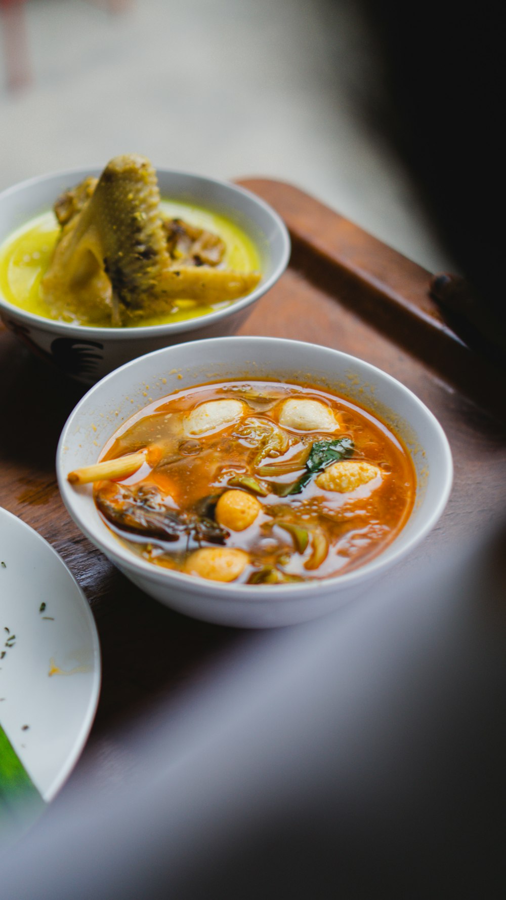 two bowls of soup on a wooden tray