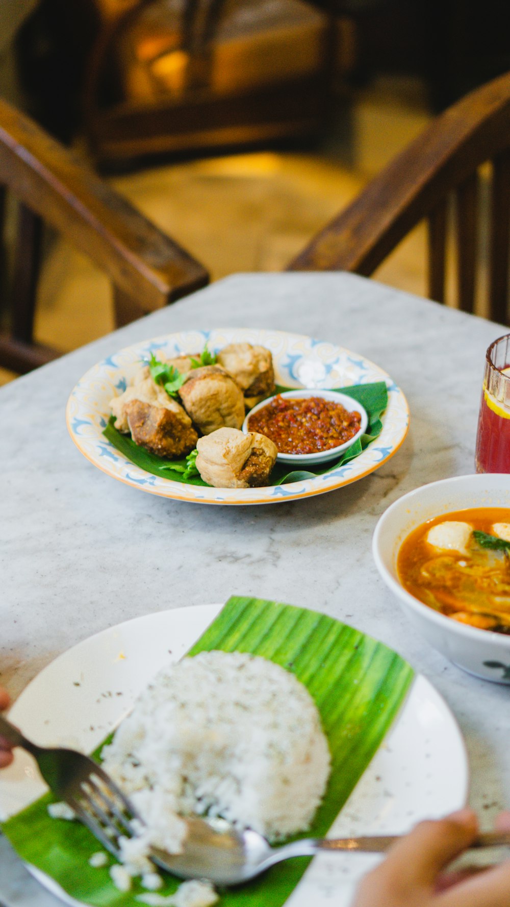 a table topped with plates of food and a bowl of soup