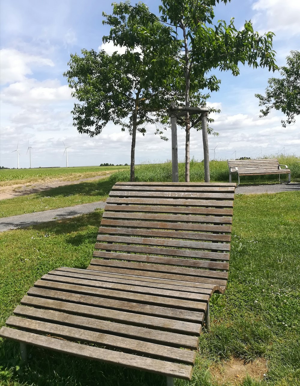 a wooden bench sitting on top of a lush green field