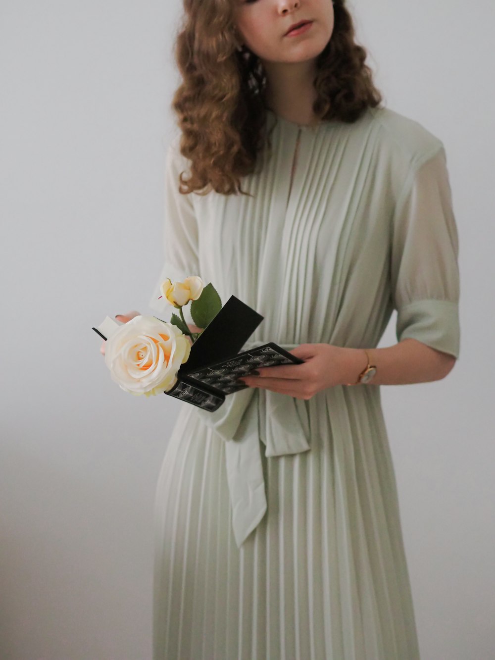 a woman in a white dress holding a bouquet of flowers