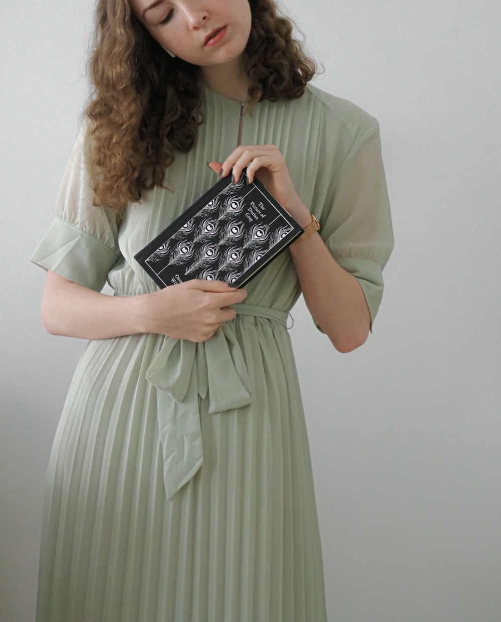 a woman in a green dress holding a black box